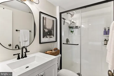 a bathroom with a sink vanity mirror and toilet