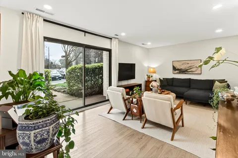 a living room with furniture a flat screen tv and a large window