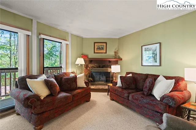 a living room with furniture a large window and a fireplace
