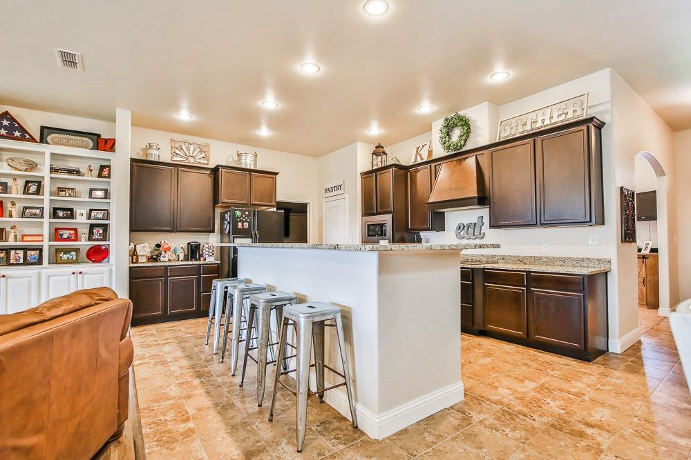 9103 Rochester Avenue Lubbock, TX 79424 - Photo 10 of 26 a kitchen with stainless steel appliances a stove a sink cabinets and a refrigerator