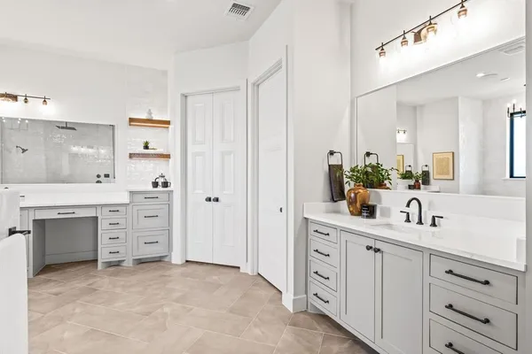 a spacious bathroom with a double vanity sink a mirror a and a window