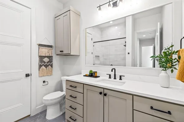 a bathroom with a sink a toilet and shower