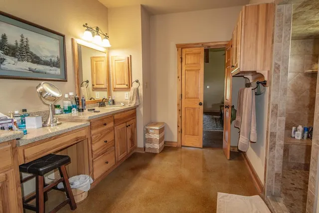 a bathroom with a granite countertop tub sink and mirror