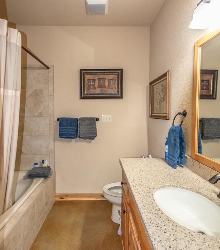 2657 West Sabinal Road Utopia, TX 78884 - Photo 32 of 36 a bathroom with a granite countertop tub sink and mirror