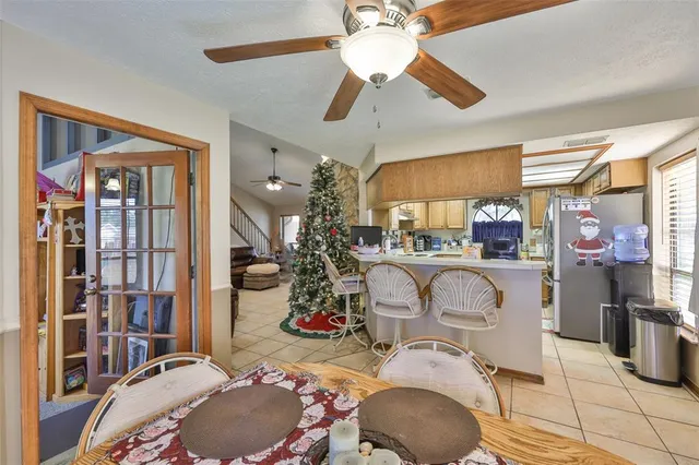 a room with lots of white furniture a chandelier and a window