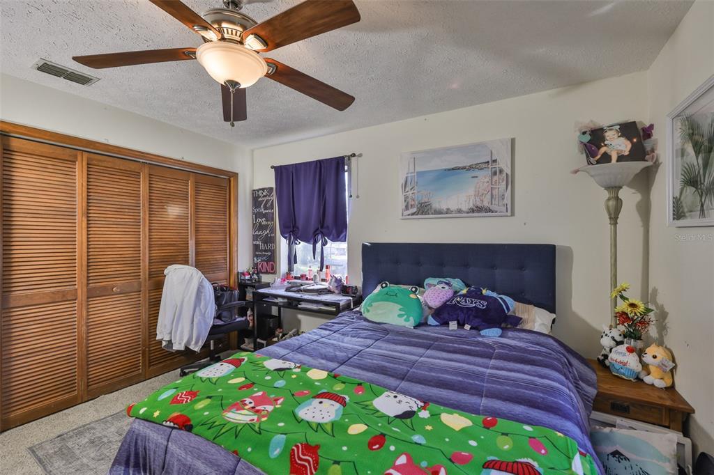 411 12th Street Southwest Ruskin, FL 33570 - Photo 27 of 33 a bedroom with a bed and a table in it