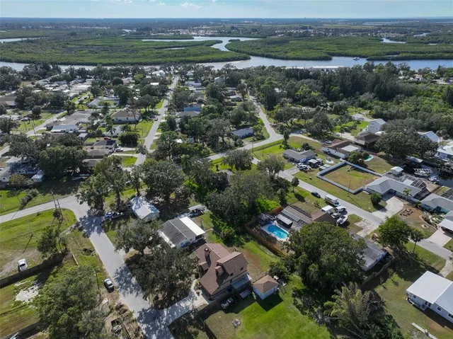 an aerial view of residential houses with outdoor space and trees