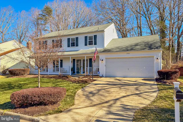 a view of a house with a yard and large tree