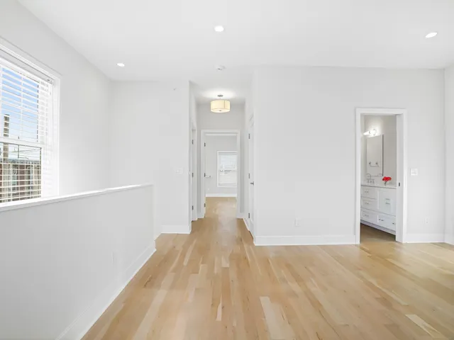 a view of a big room with wooden floor and windows