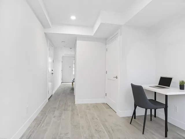 a view of a workspace with furniture and wooden floor