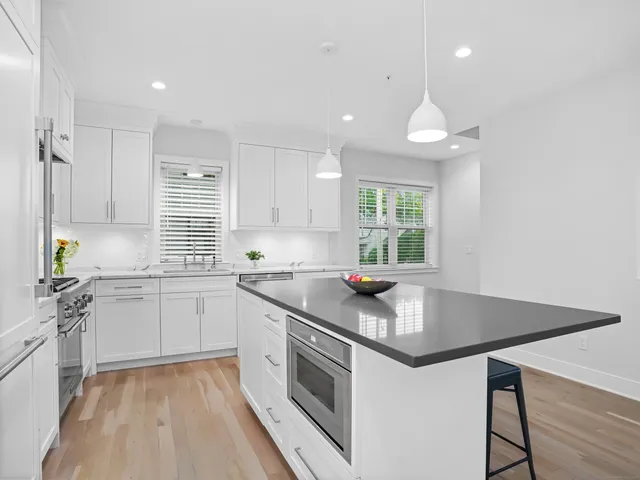 a kitchen that has a sink a window and stainless steel appliances