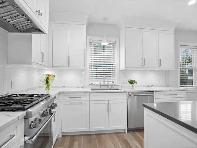 a kitchen with white cabinets and appliances