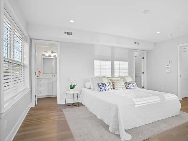 a spacious bedroom with a bed a closet and a large window