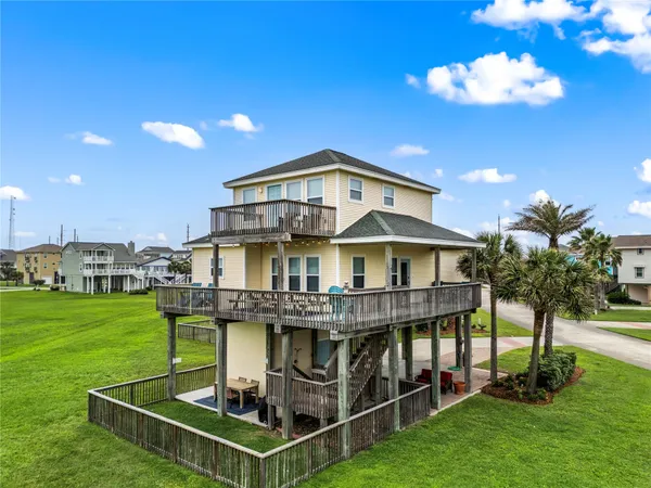 a view of a house with a big yard and large trees