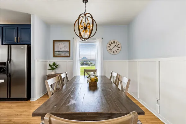 a view of a dining room with furniture a chandelier and wooden floor