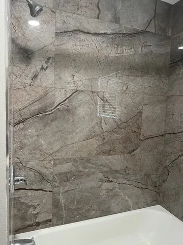 a bathroom with a granite countertop toilet sink and mirror