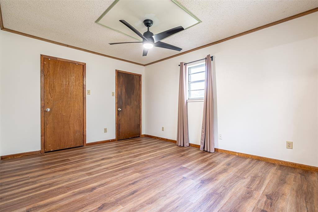 501 Endora Dublin, TX 76446 - Photo 25 of 39 a view of an empty room with wooden floor and a ceiling fan