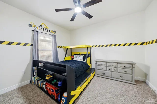 a bedroom with a bed a dresser and a chandelier