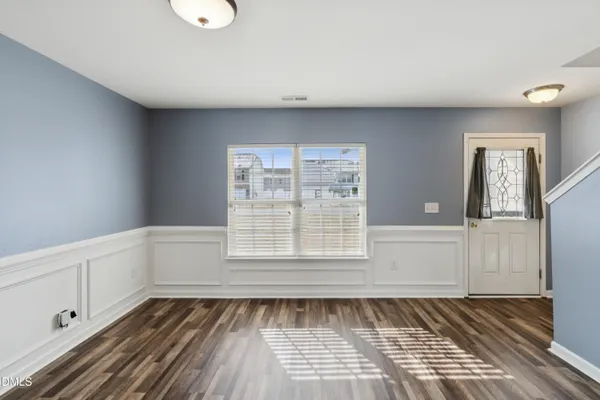 a view of a kitchen with refrigerator and wooden floor