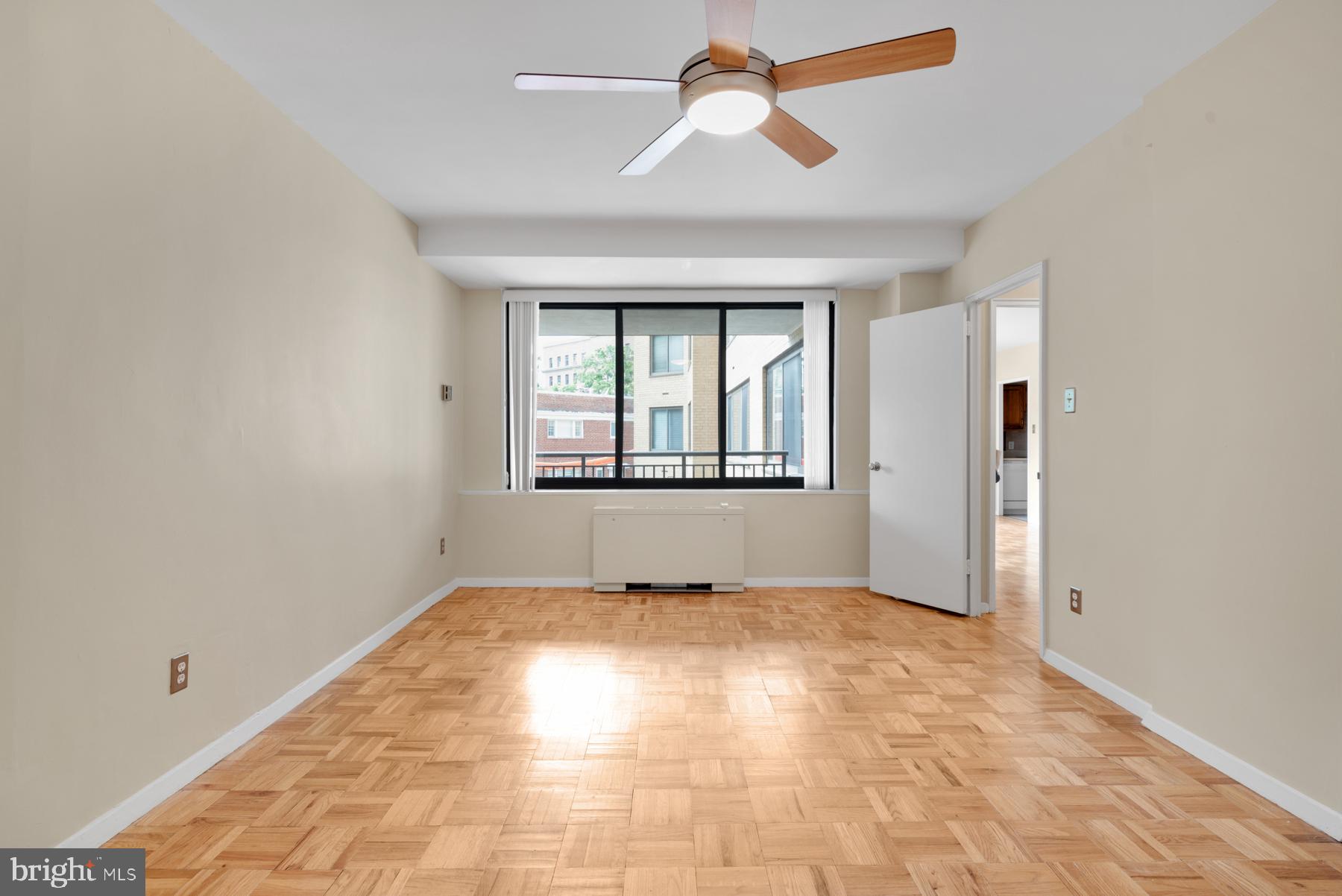 4740 Connecticut Avenue Northwest, Unit 414 Washington, DC 20008 - Photo 12 of 33 an empty room with windows and chandelier fan