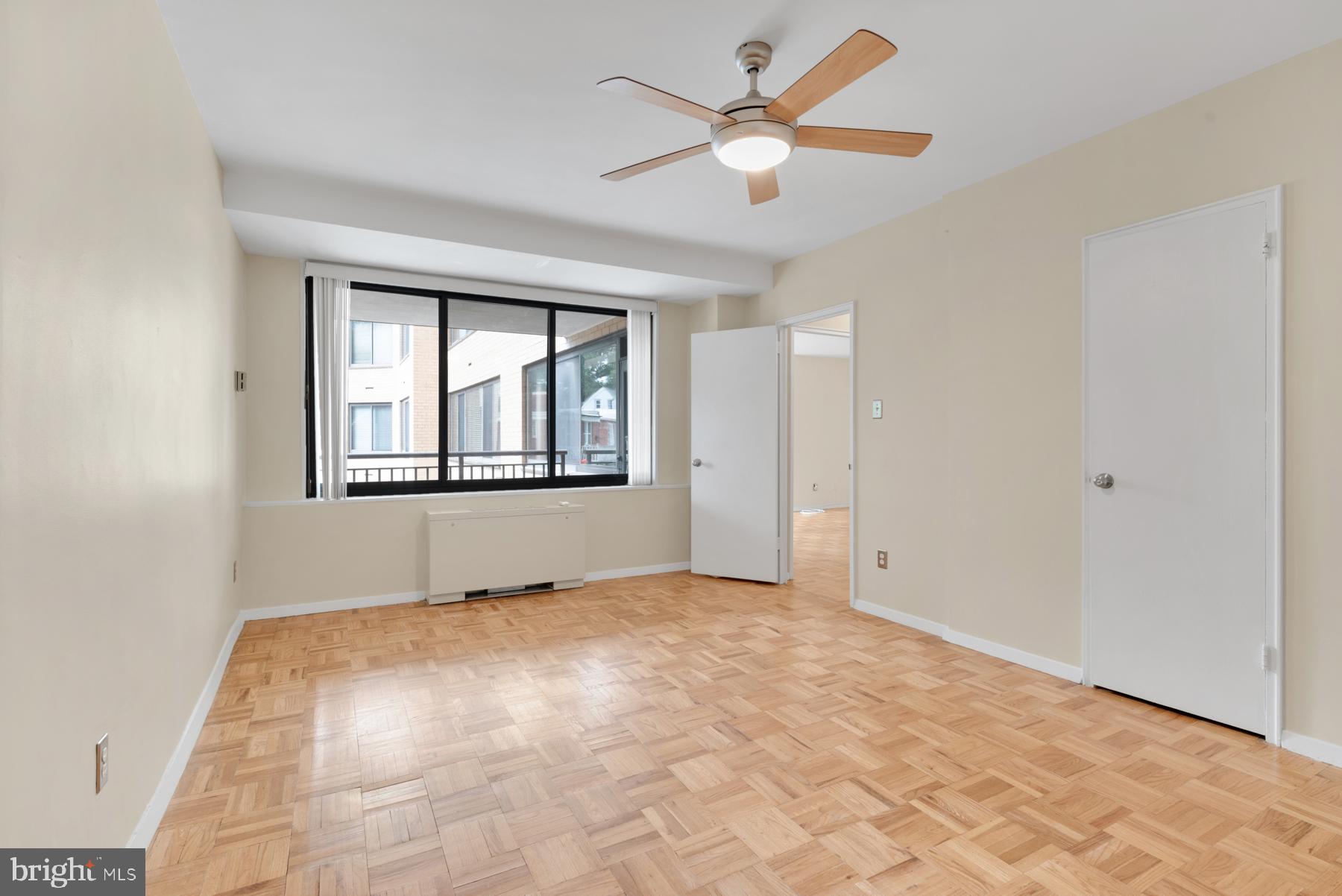 4740 Connecticut Avenue Northwest, Unit 414 Washington, DC 20008 - Photo 13 of 33 an empty room with chandelier fan and windows