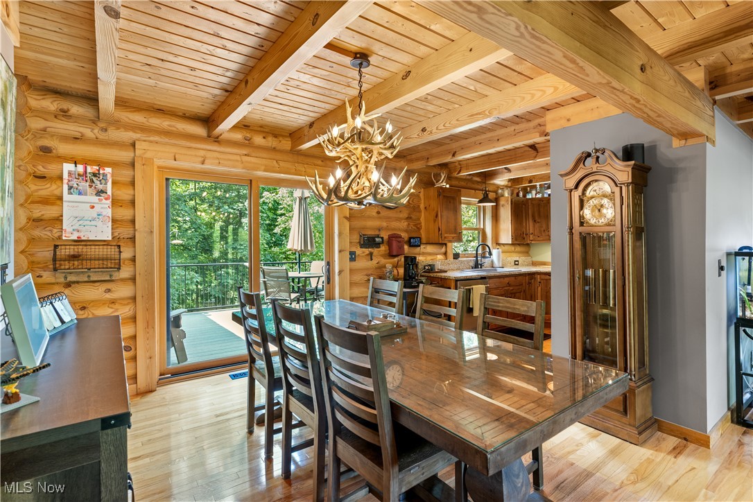 1784 North Medina Line Road Akron, OH 44333 - Photo 5 of 50 Dining area with light wood-style floors, a wooden ceiling with exposed beams, and a chandelier