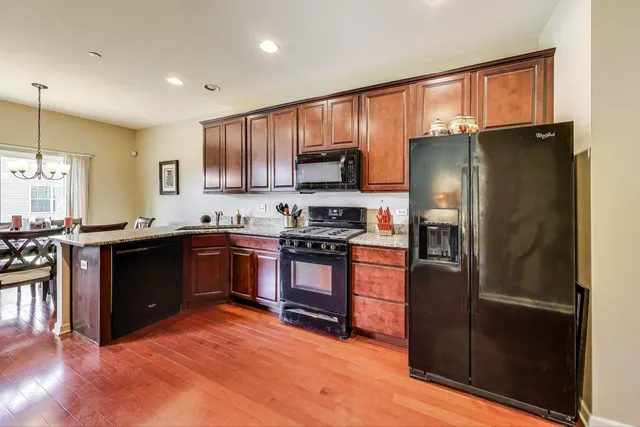 a kitchen with granite countertop a refrigerator stove and oven
