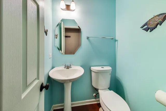 a bathroom with a toilet sink and mirror