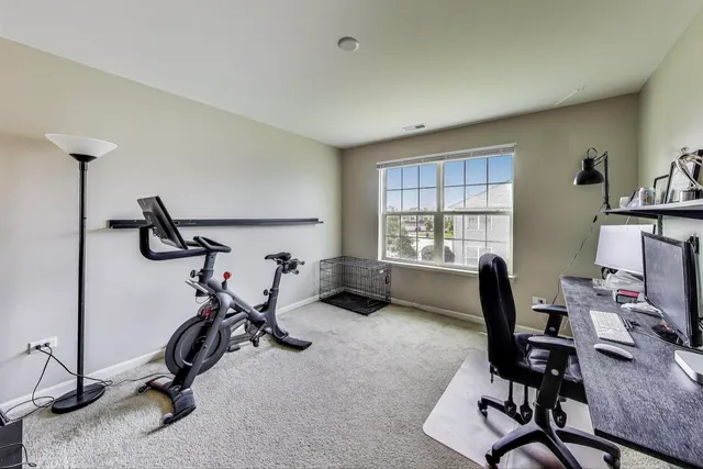 a view of a workspace with furniture and a window