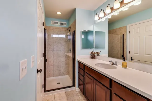 a bathroom with a shower sink and mirror