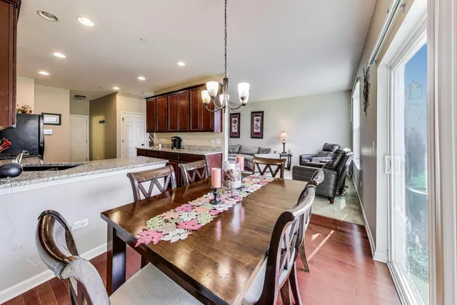 a kitchen with granite countertop lots of wooden furniture a sink and a chandelier