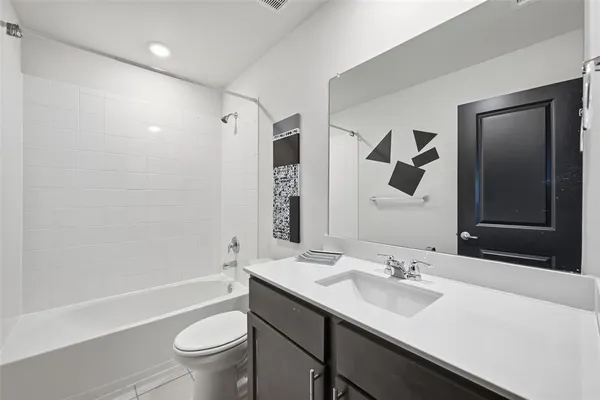 a bathroom with a sink a toilet and a large mirror