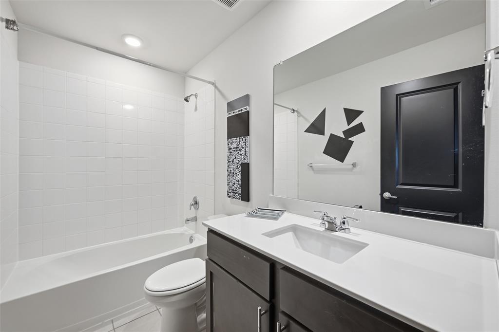 617 Range Drive Princeton, TX 75407 - Photo 18 of 26 a bathroom with a sink a toilet and a large mirror