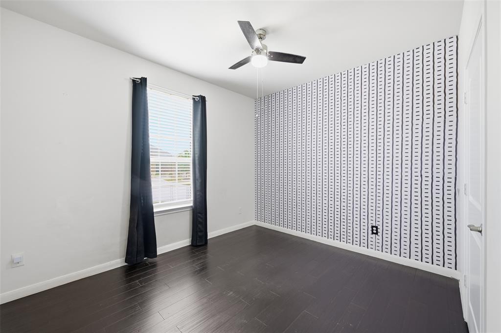 617 Range Drive Princeton, TX 75407 - Photo 23 of 26 an empty room with wooden floor and a ceiling fan