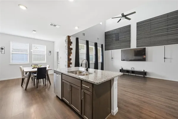 a kitchen with a table chairs and a wooden floor
