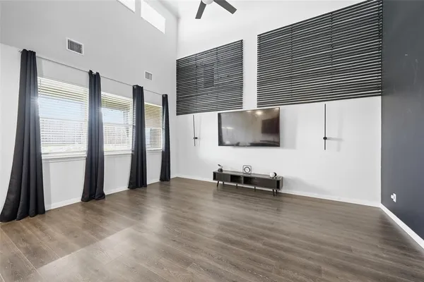 a view of a livingroom with wooden floor and furniture
