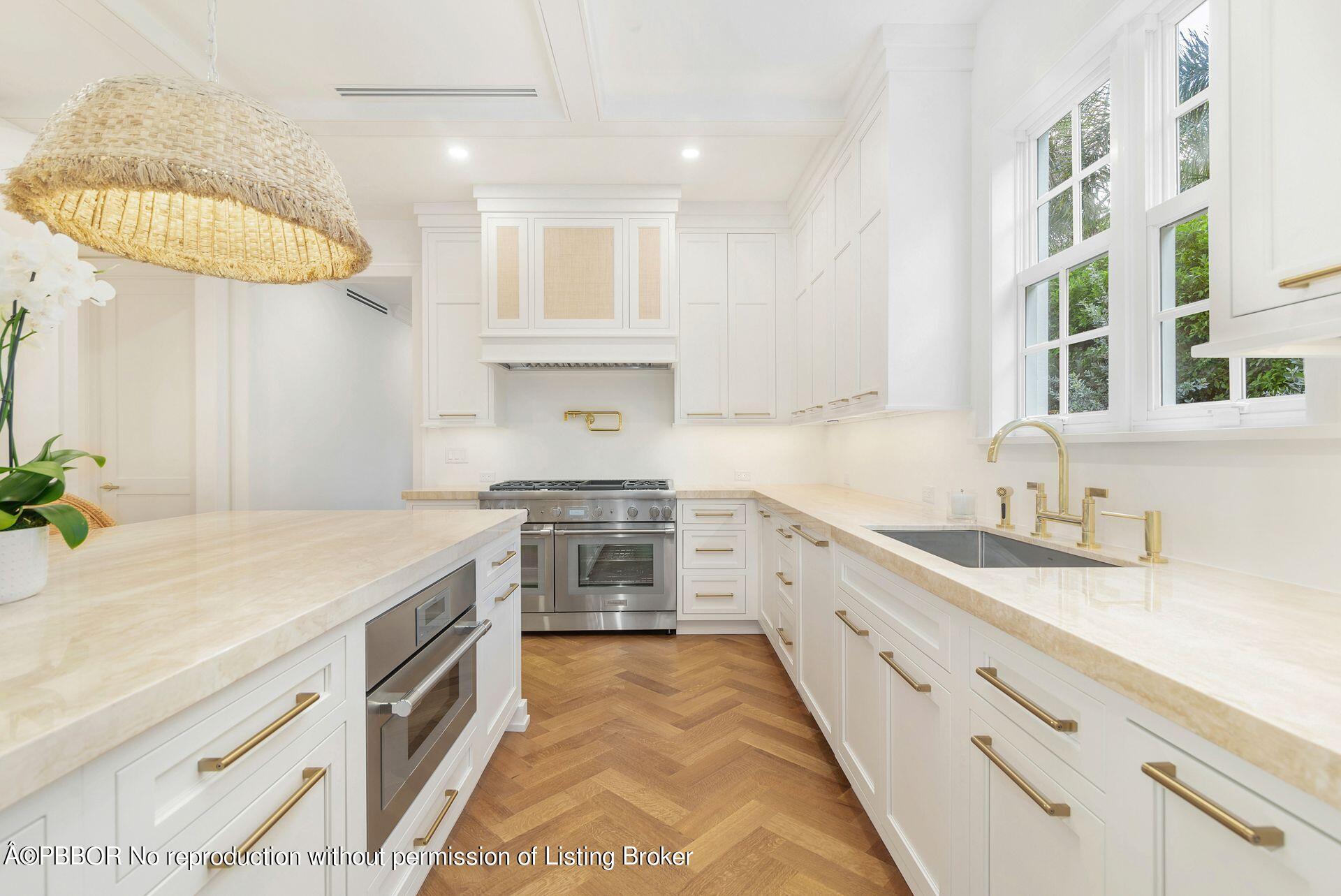 320 Sunset Road West Palm Beach, FL 33401 - Photo 15 of 35 a kitchen with a sink dishwasher a stove and a dining table with wooden floor