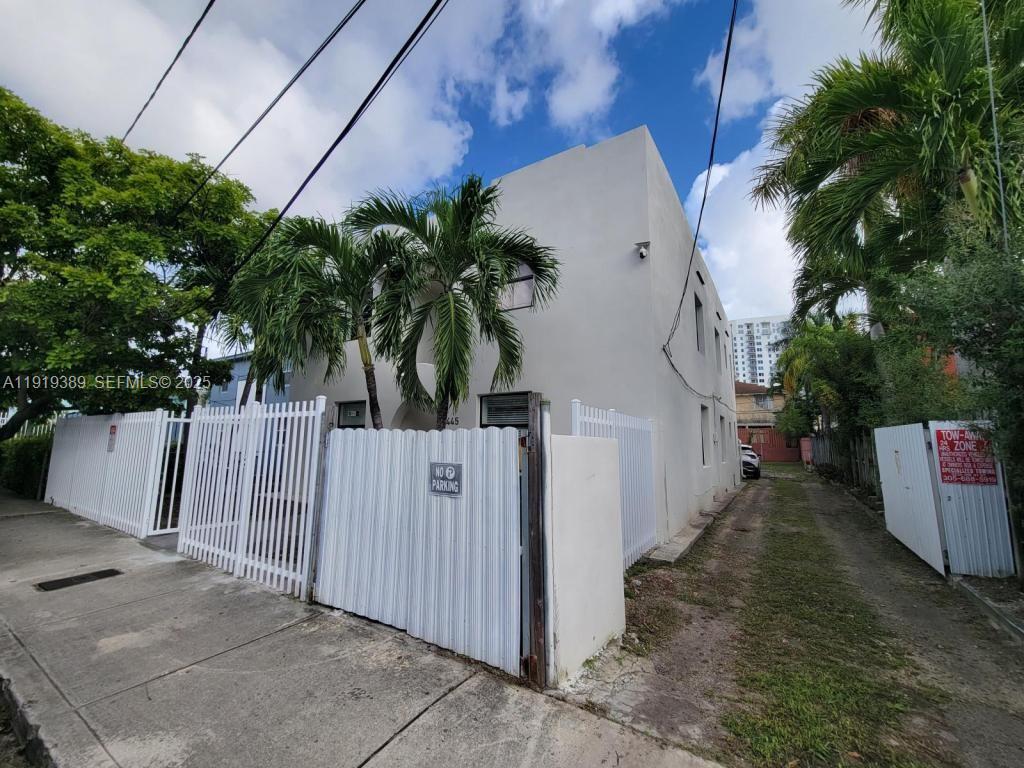 445 Southwest 3rd Street, Unit 1 Miami, FL 33130 - Photo 11 of 11 a view of a white house with a small yard and wooden fence