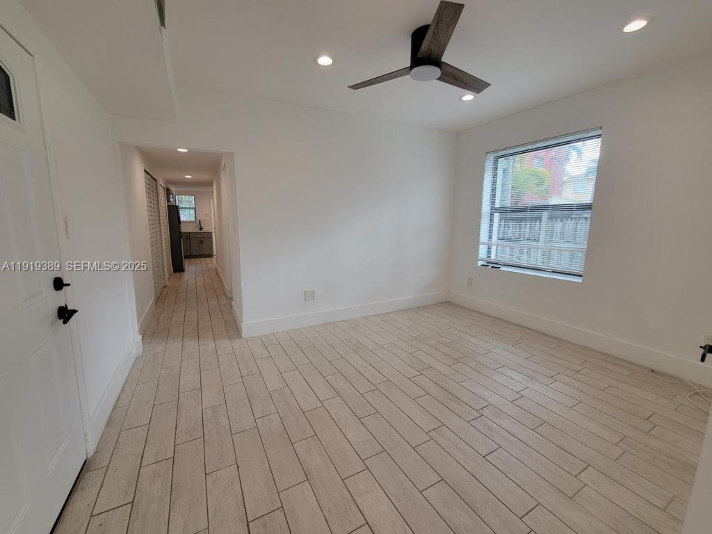445 Southwest 3rd Street, Unit 1 Miami, FL 33130 - Photo 3 of 11 an empty room with wooden floor and windows