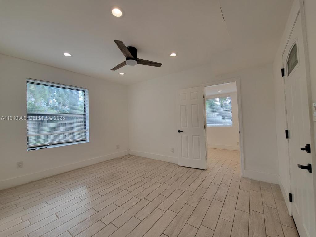 445 Southwest 3rd Street, Unit 1 Miami, FL 33130 - Photo 5 of 11 an empty room with wooden floor and windows