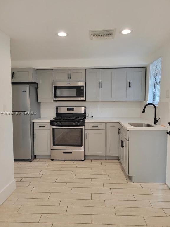 445 Southwest 3rd Street, Unit 1 Miami, FL 33130 - Photo 8 of 11 a kitchen with stainless steel appliances a stove sink and cabinets