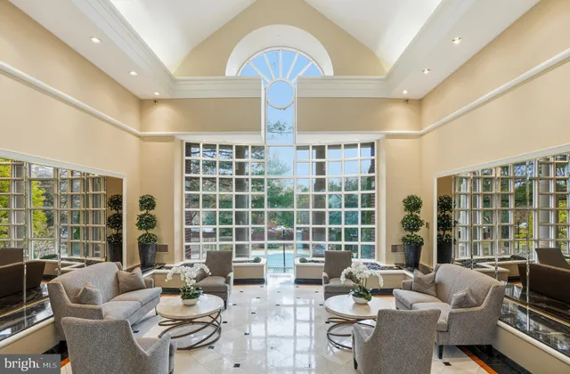 a living room with furniture and floor to ceiling windows