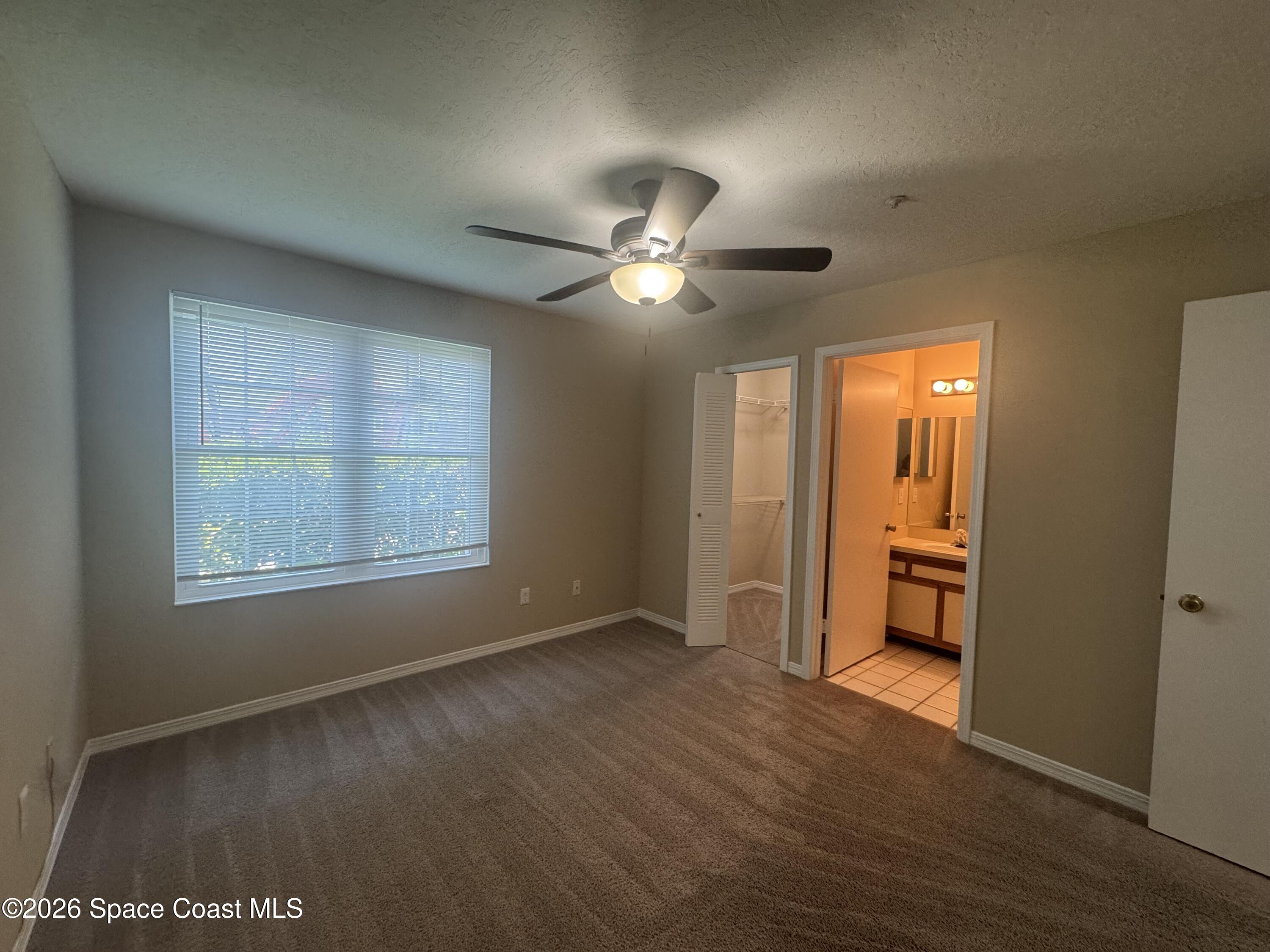 7667 North Wickham Road, Unit 1107 Melbourne, FL 32940 - Photo 8 of 19 an empty room with wooden floor and windows