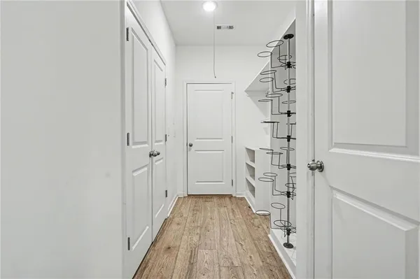 a view of a hallway with wooden floor and staircase