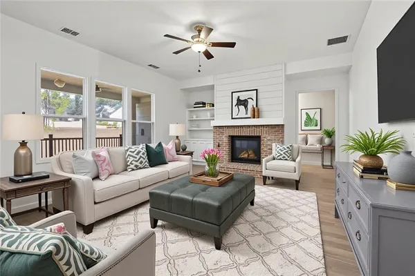 a living room with furniture fireplace and a large window