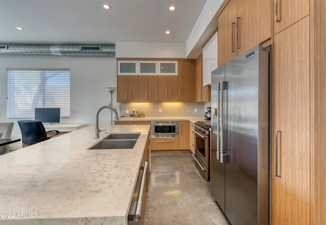 a kitchen with granite countertop a refrigerator and a sink