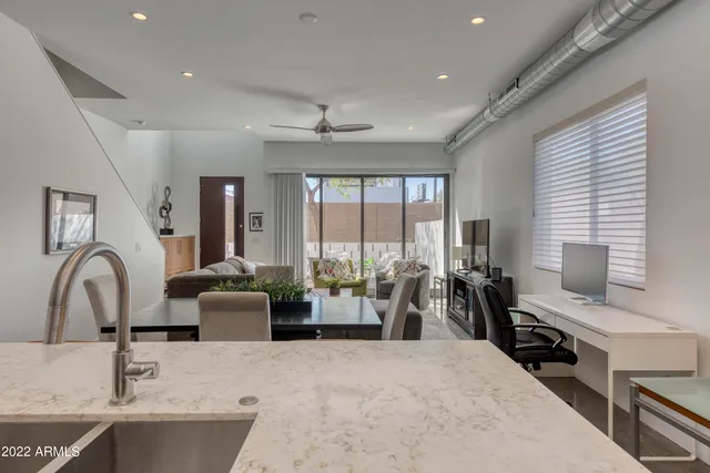 a living room with furniture a large window and flat screen tv