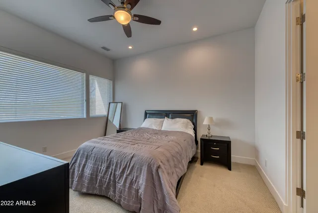 a bedroom with a bed and a ceiling fan