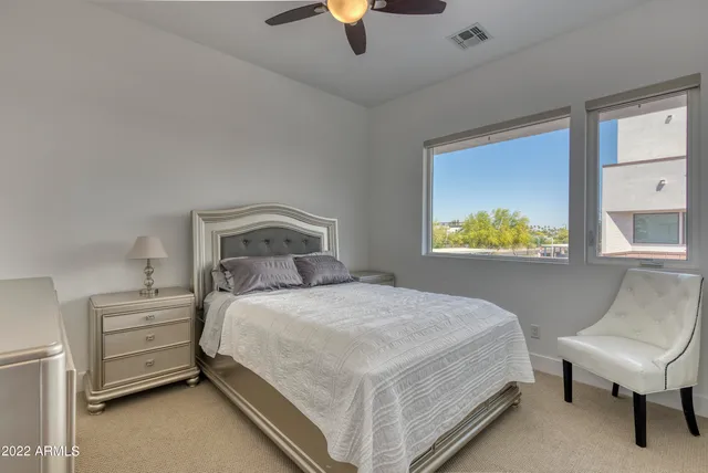 a bedroom with a bed a couch and a chandelier