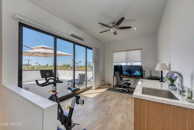 a view of a workspace with furniture and a window